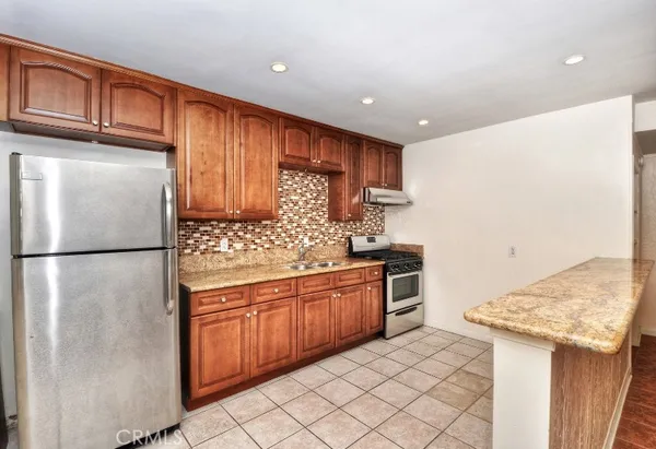 a kitchen with stainless steel appliances granite countertop a refrigerator sink and cabinets