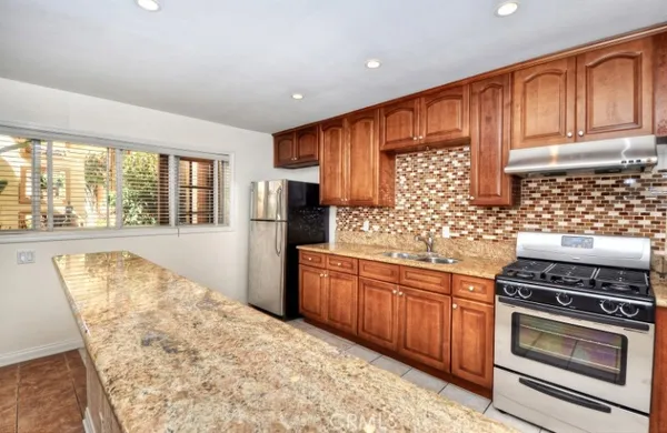 a kitchen with stainless steel appliances wooden cabinets and a stove top oven