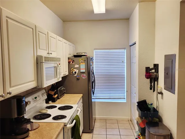 a kitchen with white cabinets and white appliances