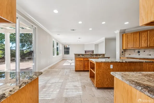a kitchen with stainless steel appliances granite countertop a sink a stove and a large window