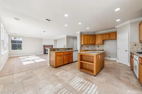 a large kitchen with stainless steel appliances granite countertop a stove a sink dishwasher and a refrigerator