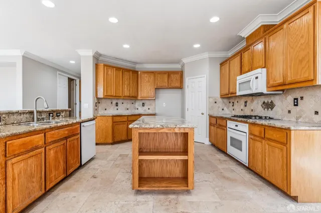 a kitchen with stainless steel appliances granite countertop a stove a sink and a microwave