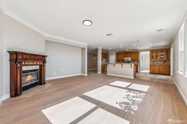 a view of an empty room with wooden floor and cabinet