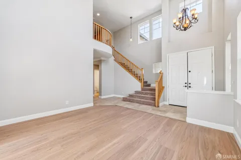 a view of a livingroom with wooden floor and a ceiling fan