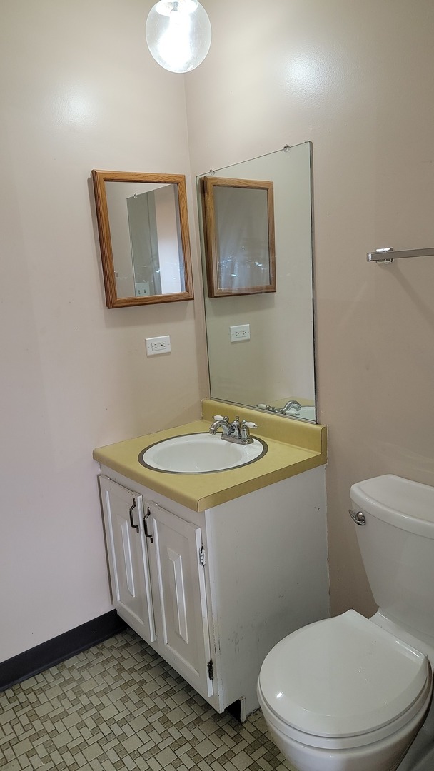 14621 Greenwood Road, Unit 408 Dolton, IL 60419 - Photo 14 of 25 a bathroom with a toilet a sink and mirror