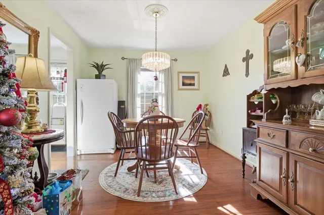 a view of a hallway with wooden floor and a bathroom