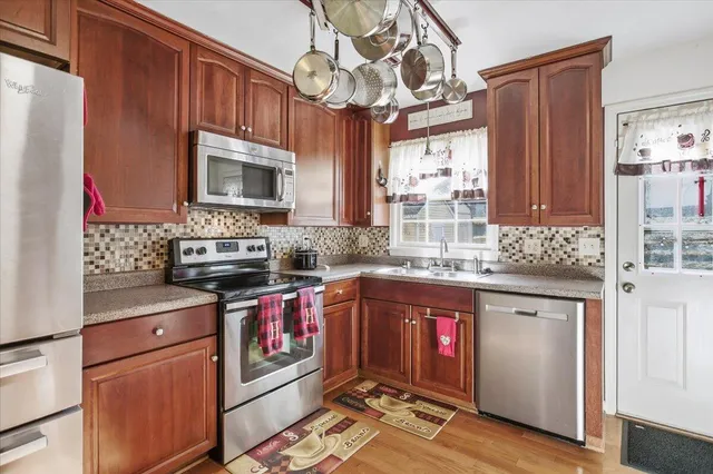 a kitchen with stainless steel appliances granite countertop a refrigerator a stove a sink and dishwasher