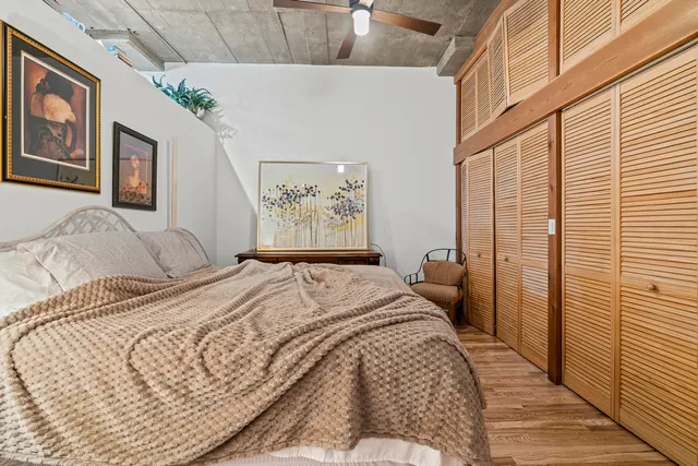 a bedroom with a bed painting on wall and a large window