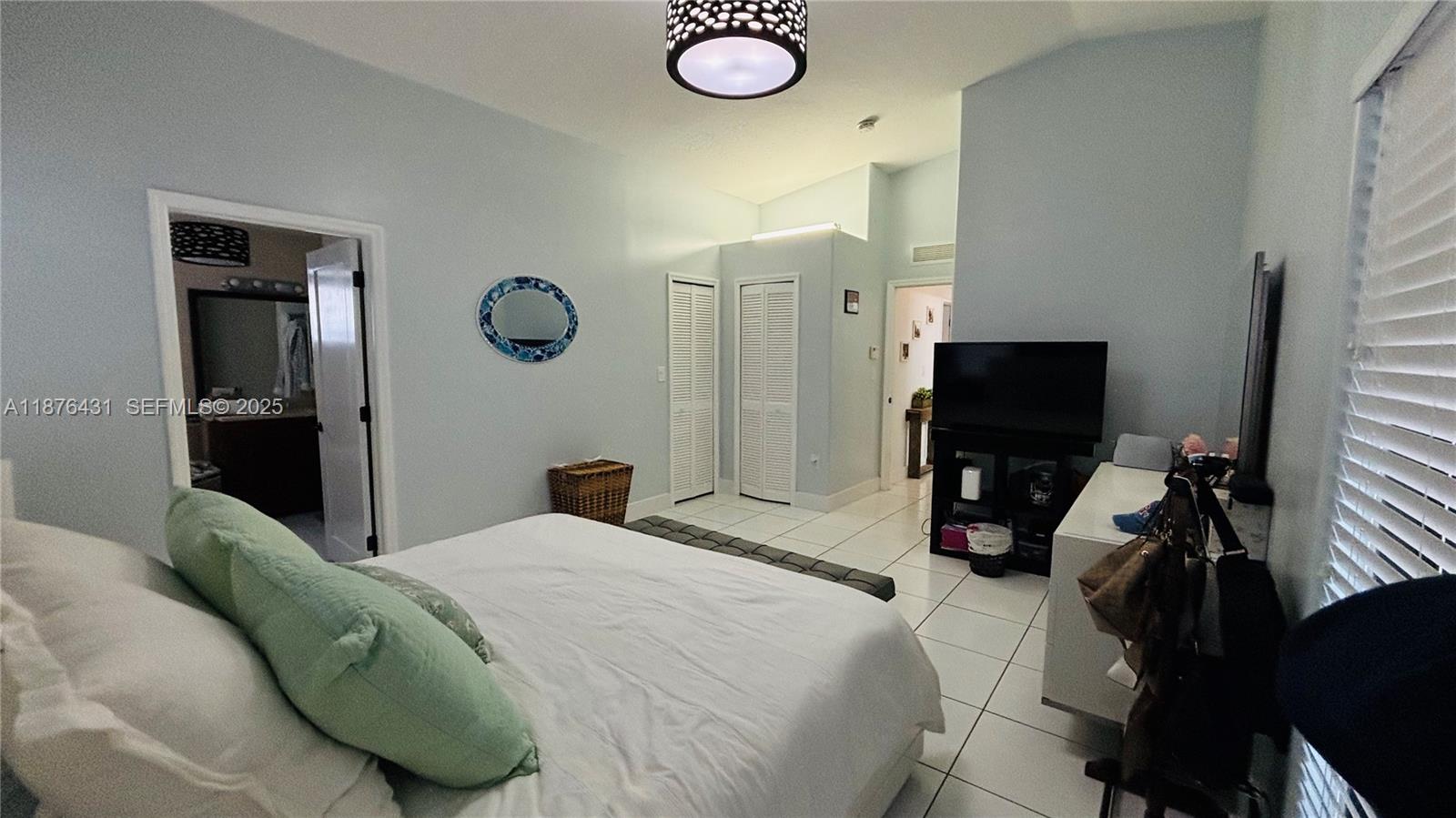 16605 Southwest 90th Street Miami, FL 33196 - Photo 22 of 35 a bedroom with a bed and a flat screen tv