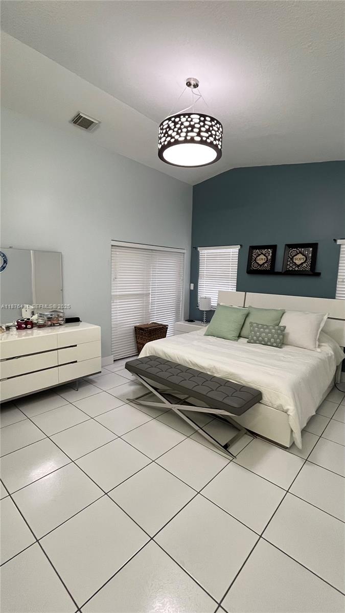 16605 Southwest 90th Street Miami, FL 33196 - Photo 23 of 35 a bedroom with a bed and a lamp