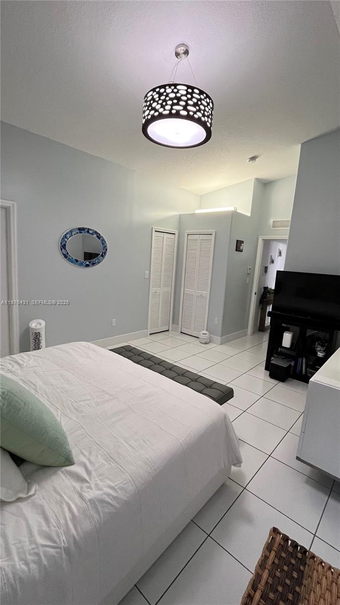 16605 Southwest 90th Street Miami, FL 33196 - Photo 24 of 35 a bedroom with a bed and a chair