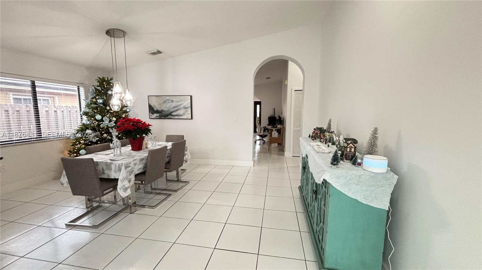 16605 Southwest 90th Street Miami, FL 33196 - Photo 4 of 35 a living room with furniture a flowers and a chandelier