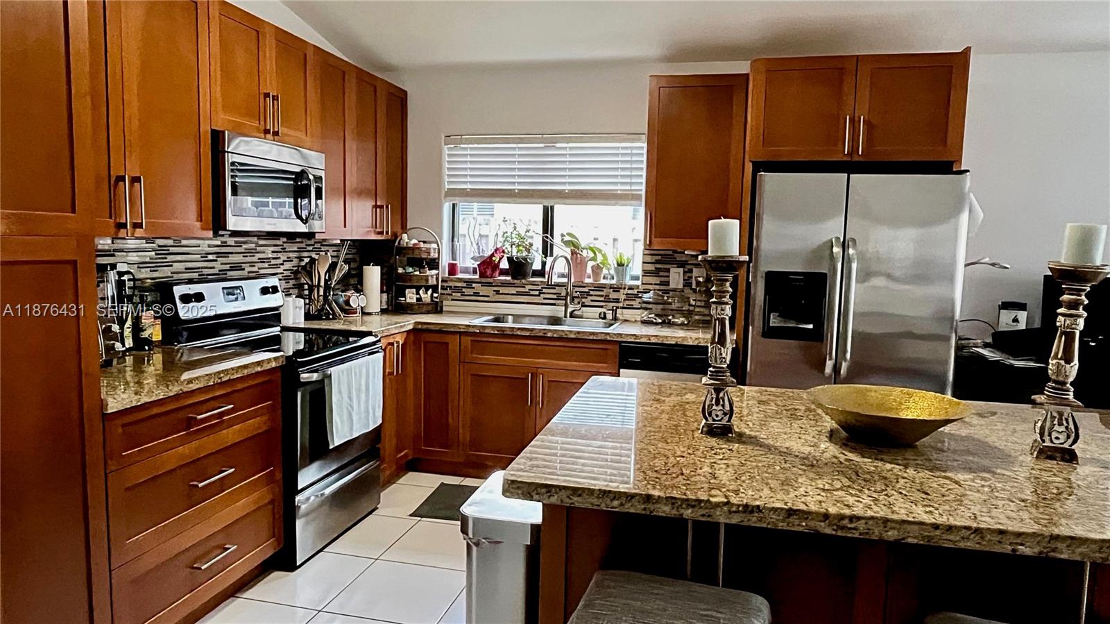 16605 Southwest 90th Street Miami, FL 33196 - Photo 9 of 35 a kitchen with stainless steel appliances granite countertop a sink stove and refrigerator