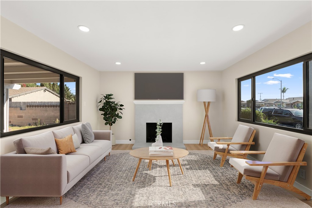 a living room with furniture fireplace and a large window