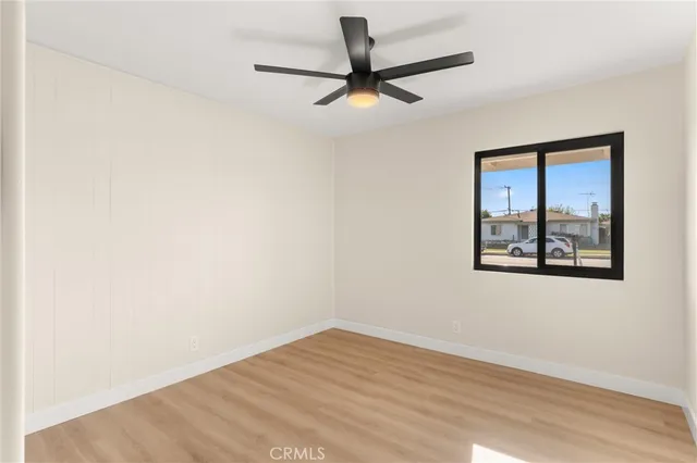 an empty room with a window and a ceiling fan