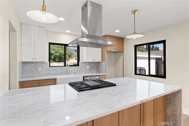 a kitchen with a stove a window and chairs