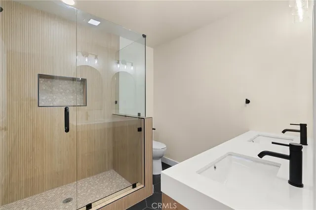 a bathroom with a sink a toilet and shower