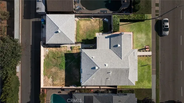 an aerial view of a residential houses with yard