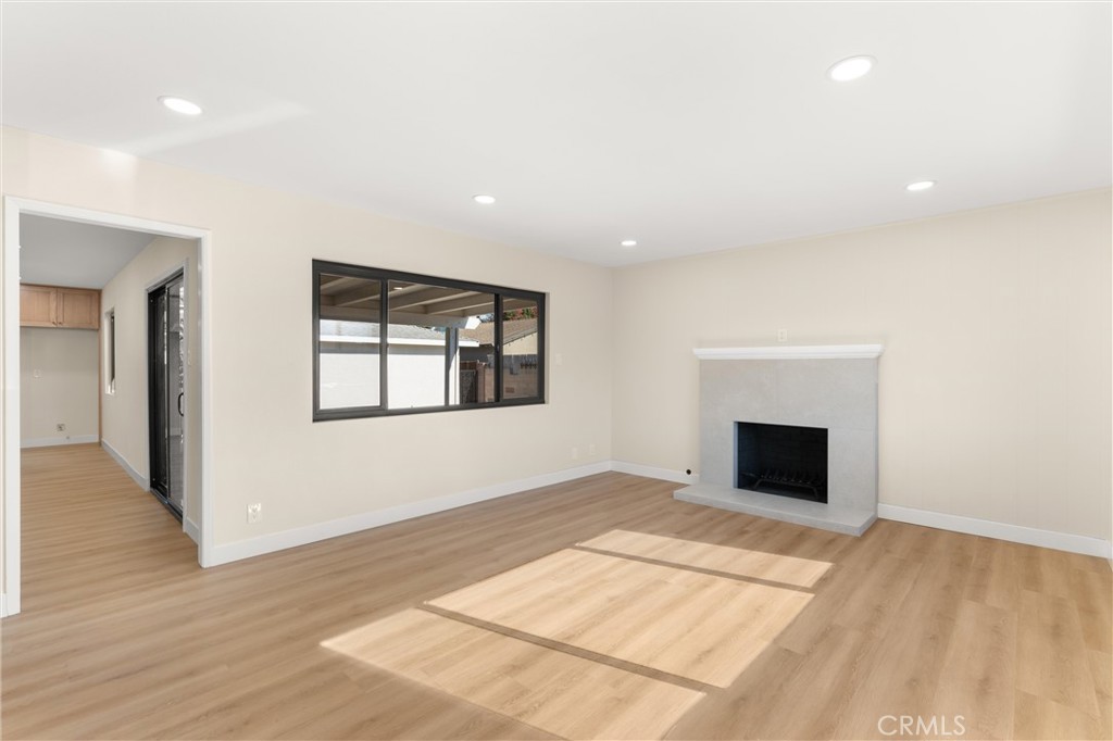13562 Springdale Street Westminster, CA 92683 - Photo 5 of 34 a view of empty room with wooden floor and fireplace