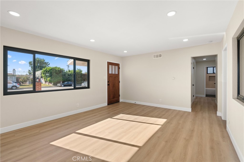 13562 Springdale Street Westminster, CA 92683 - Photo 8 of 34 a view of an empty room with wooden floor and a window