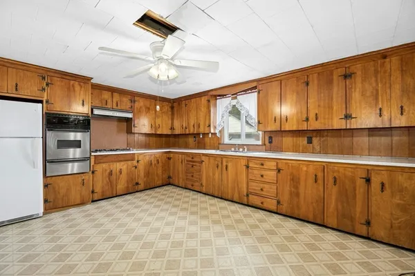 a kitchen with stainless steel appliances granite countertop a sink refrigerator and cabinets