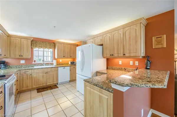 a kitchen with a sink dishwasher stove and refrigerator with wooden floor