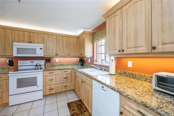 a kitchen with granite countertop a sink stainless steel appliances and cabinets