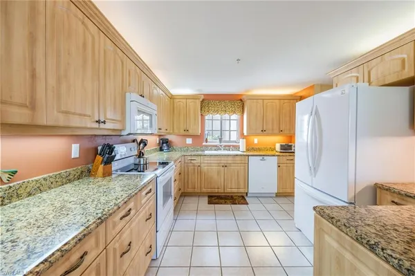 a kitchen with a sink a counter top space stainless steel appliances and cabinets
