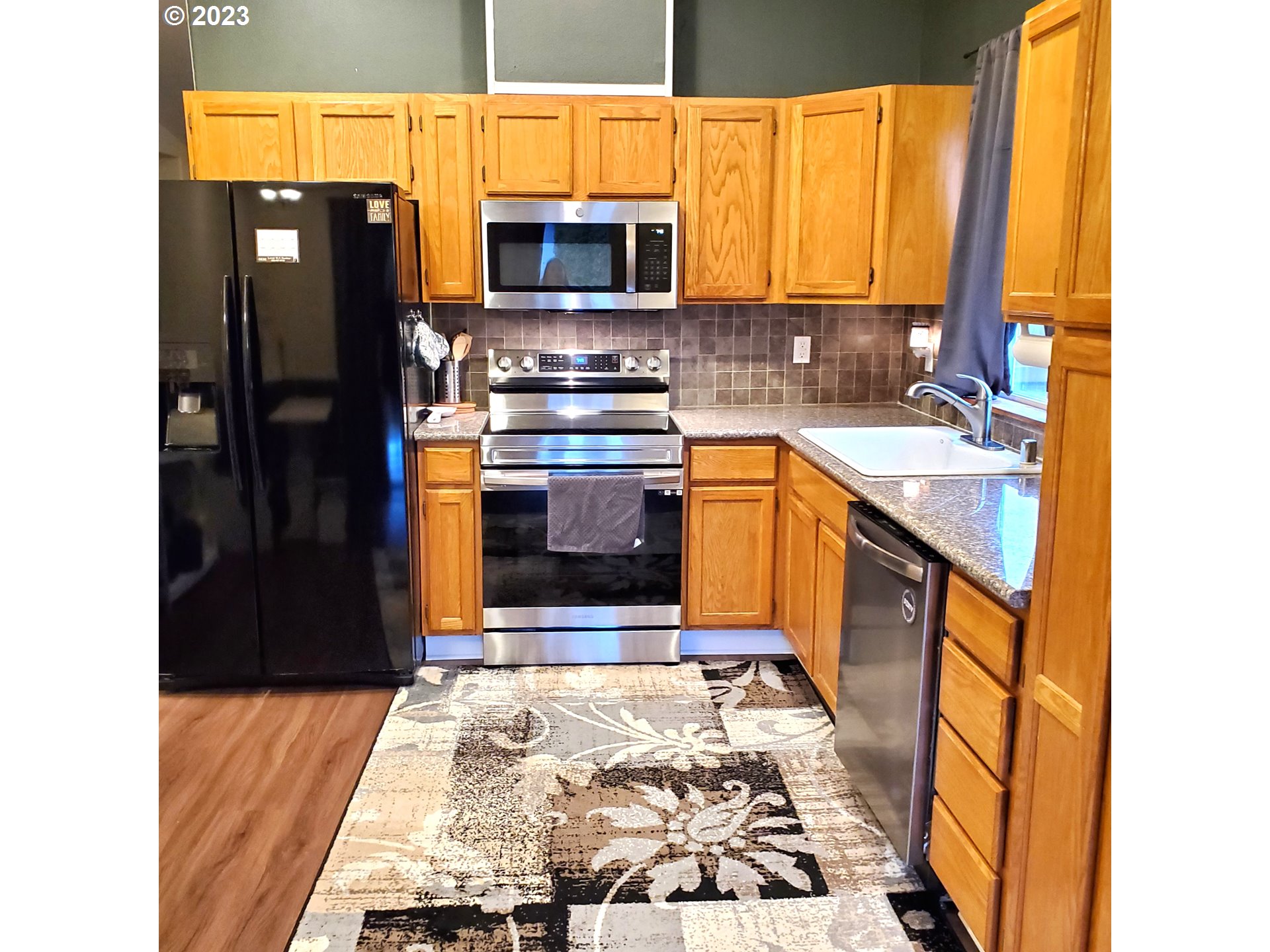 1399 North Shepherd Road Washougal, WA 98671 - Photo 8 of 32 a kitchen with stainless steel appliances granite countertop a refrigerator and a stove top oven