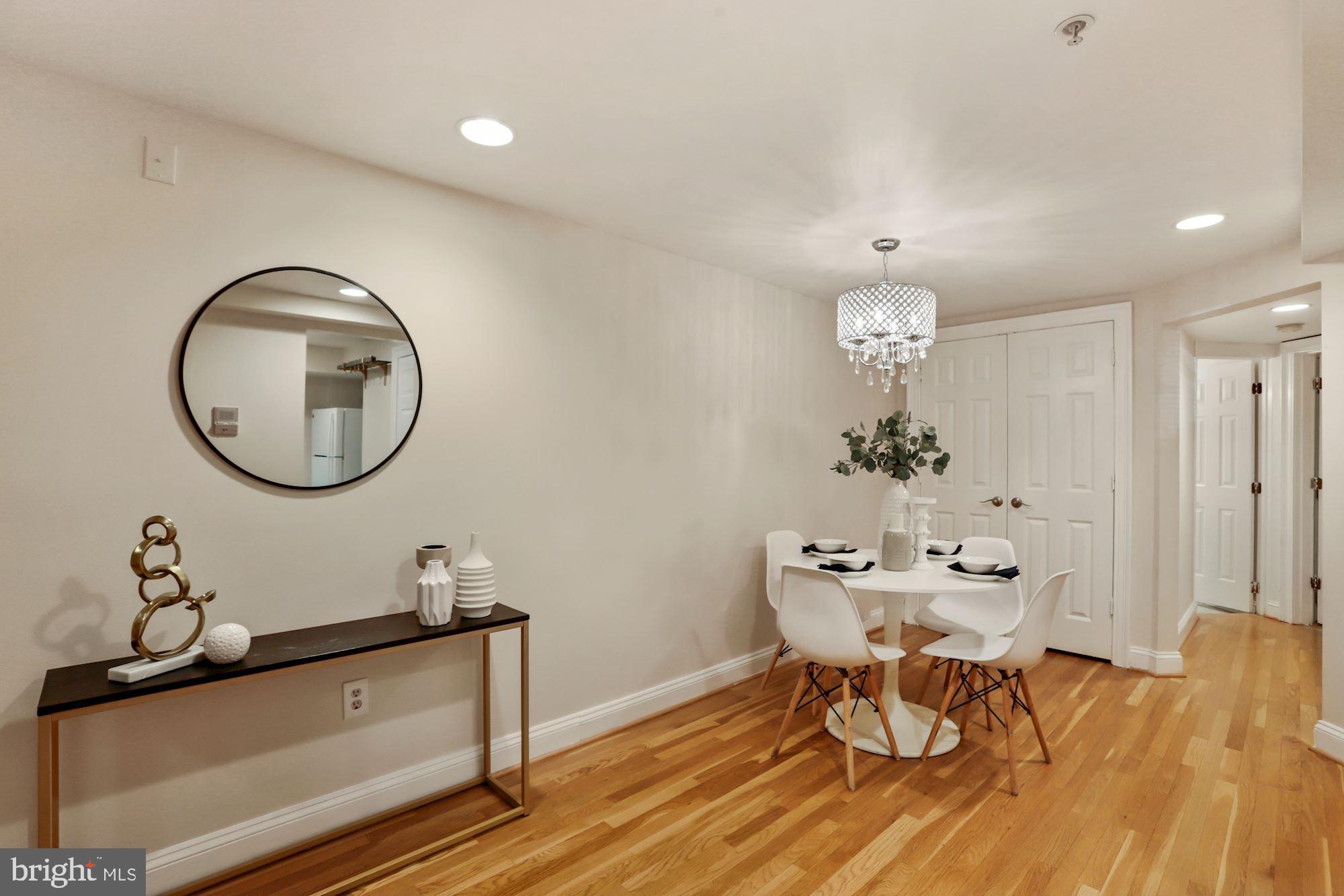 1713 18th Street Northwest, Unit B Washington, DC 20009 - Photo 8 of 23 a dining room with wooden floor a chandelier a wooden table and chairs