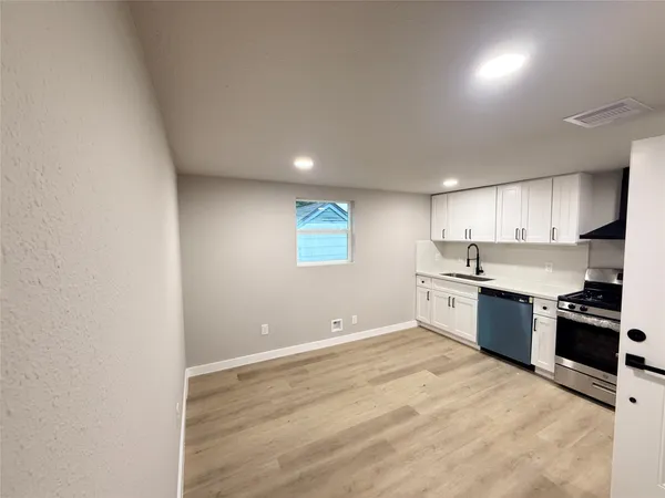an empty room with kitchen view