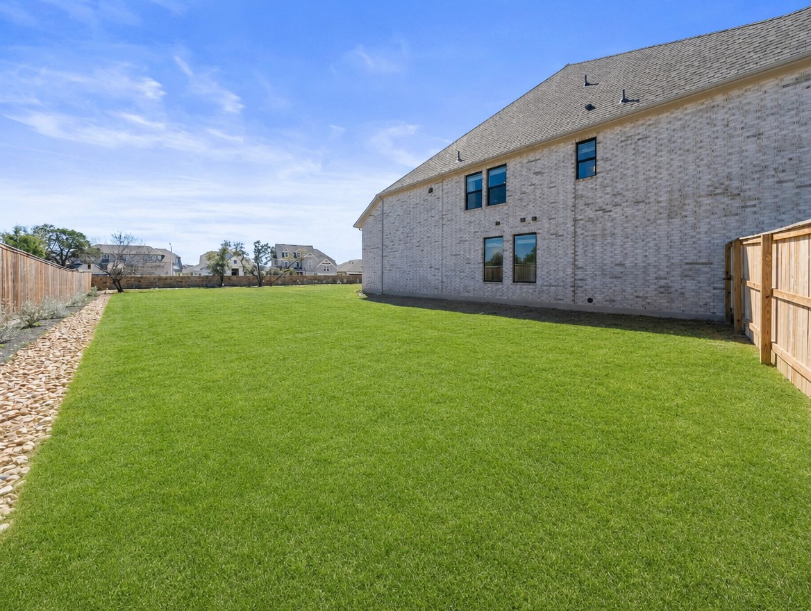 1440 Riva Ridge Drive Leander, TX 78641 - Photo 31 of 37 A spacious, verdant yard provides ample outdoor living space next to a contemporary brick home.