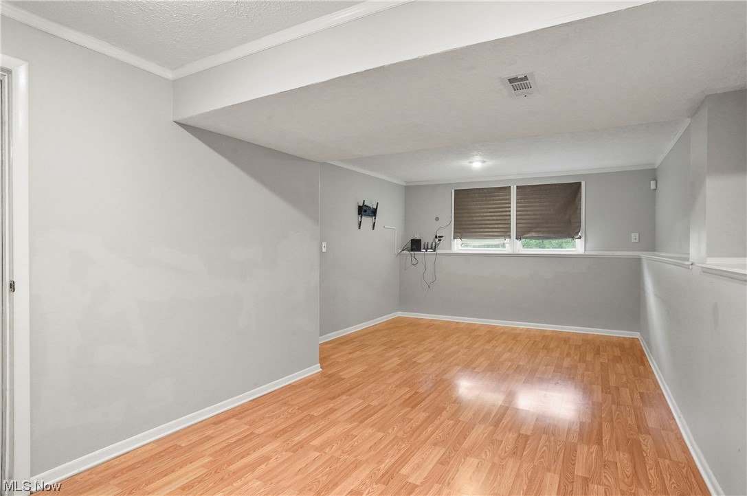 4252 Hile Road Stow, OH 44224 - Photo 23 of 31 Hardwood floored spare room featuring a textured ceiling and ornamental molding