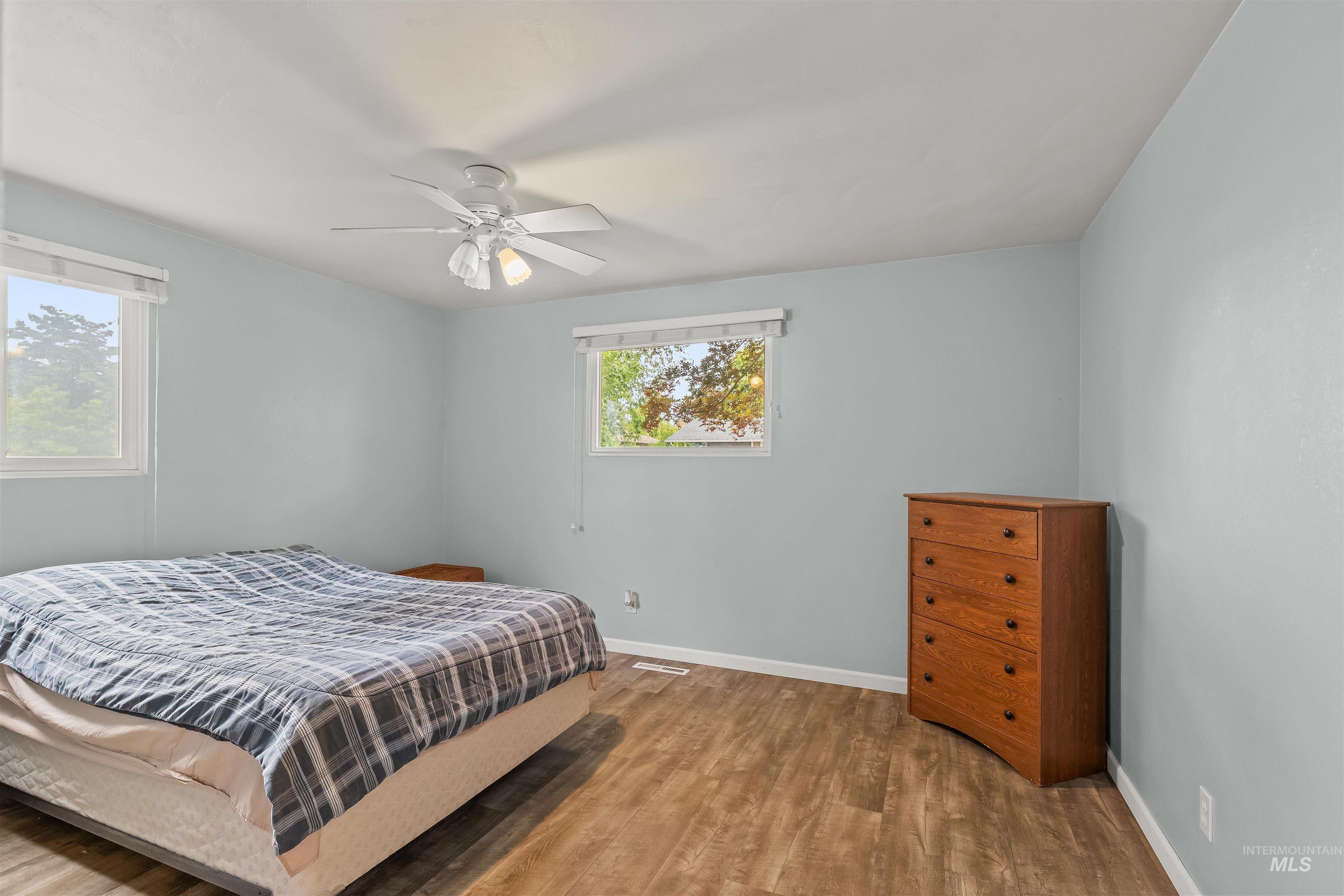 3620 18th Street Lewiston, ID 83501 - Photo 16 of 32 Spacious room featuring wood-finish flooring, two windows, and a ceiling fan with integrated lighting