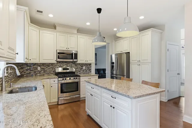 a view of a hallway with workspace and bedroom with wooden floor