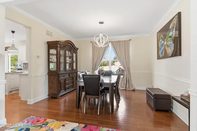 a kitchen with stainless steel appliances granite countertop a sink a stove a refrigerator cabinets and chairs