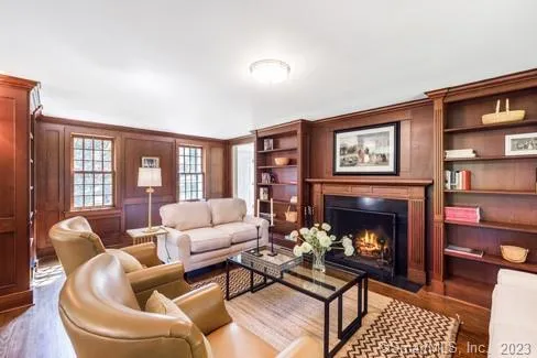 a living room with furniture a fireplace and a large window