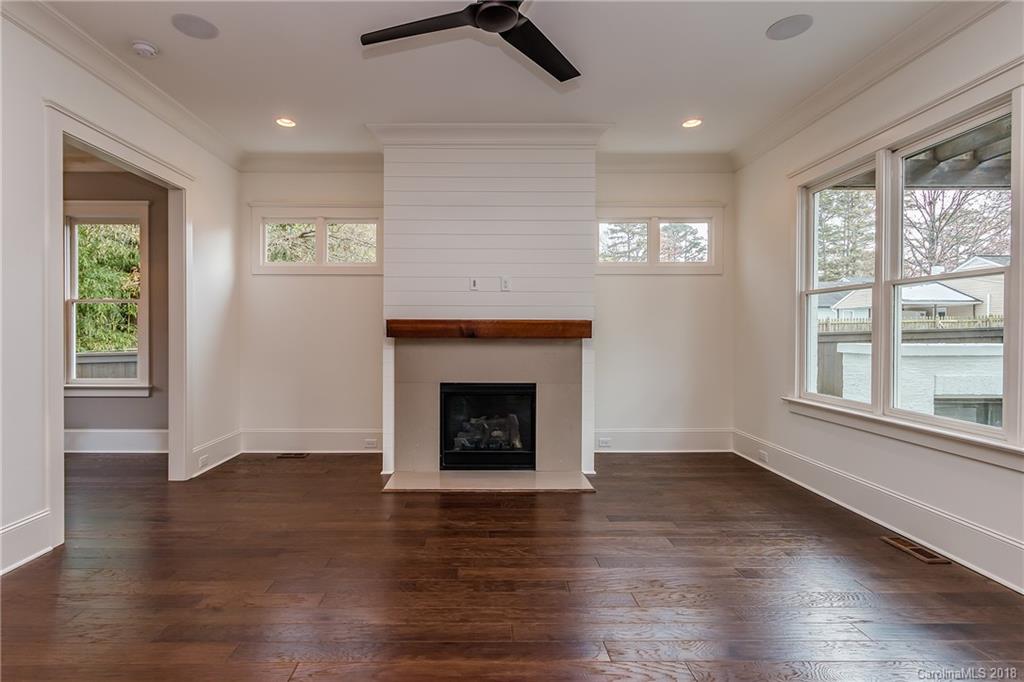 748 Ellsworth Road, Unit 47 Charlotte, NC 28211 - Photo 11 of 34 an empty room with wooden floor a ceiling fan and windows