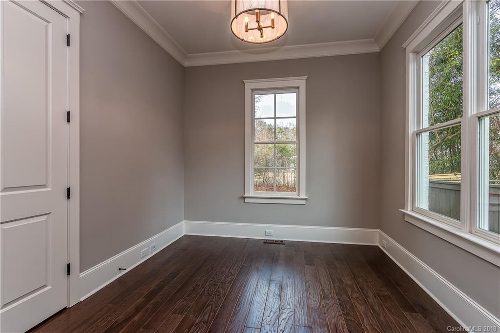 748 Ellsworth Road, Unit 47 Charlotte, NC 28211 - Photo 14 of 34 an empty room with wooden floor and windows