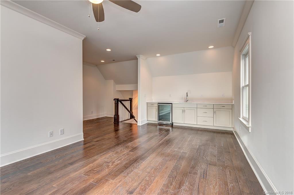 748 Ellsworth Road, Unit 47 Charlotte, NC 28211 - Photo 23 of 34 an empty room with wooden floor and windows