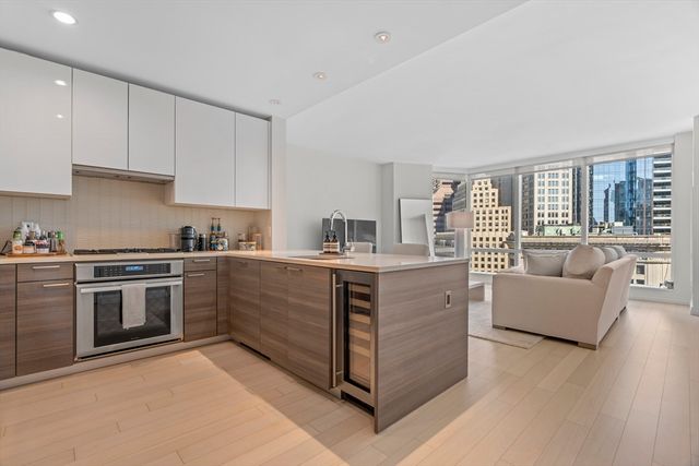 a kitchen with kitchen island granite countertop a stove top oven sink and cabinets
