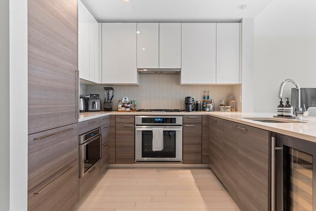 a kitchen with cabinets stainless steel appliances and sink