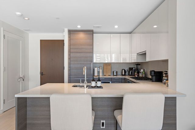 a kitchen with kitchen island a sink stainless steel appliances and cabinets