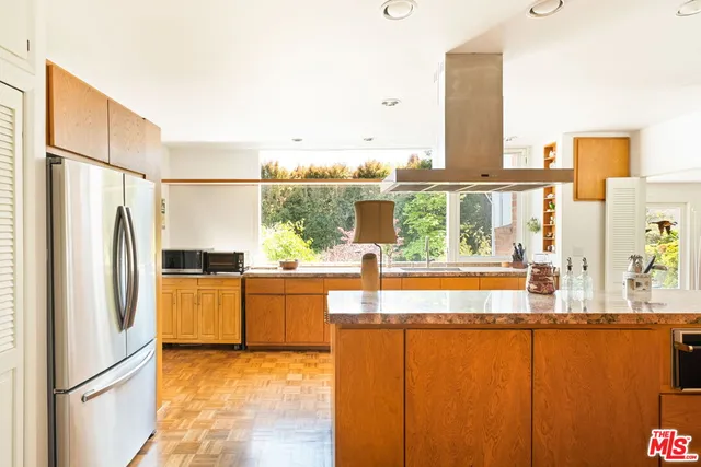 a kitchen with stainless steel appliances granite countertop a refrigerator and a stove