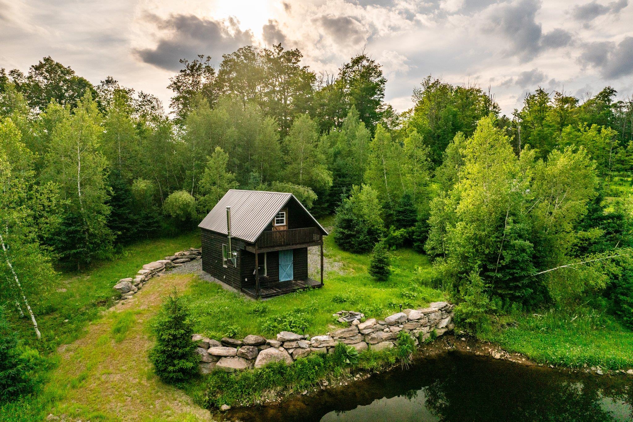 a view of a house with a big yard and large trees
