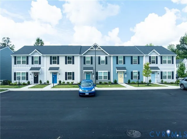 a view of a white house with a big yard and potted plants