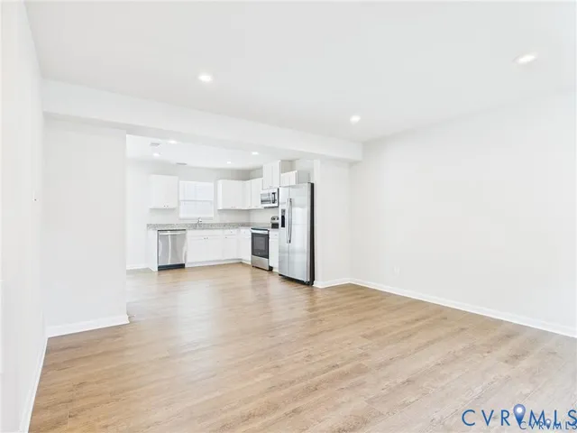 a view of empty room with a kitchen