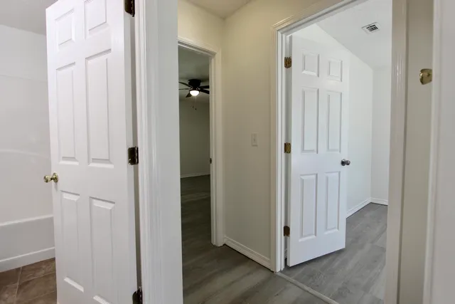 a view of a hallway with wooden floor