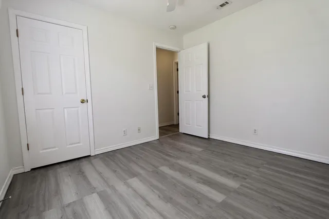 a view of an empty room with wooden floor
