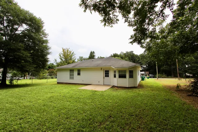 a view of a house with a yard potted plants and large tree
